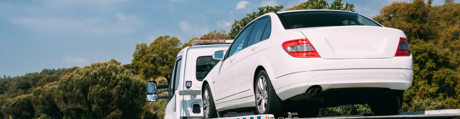 white car being carried by white truck